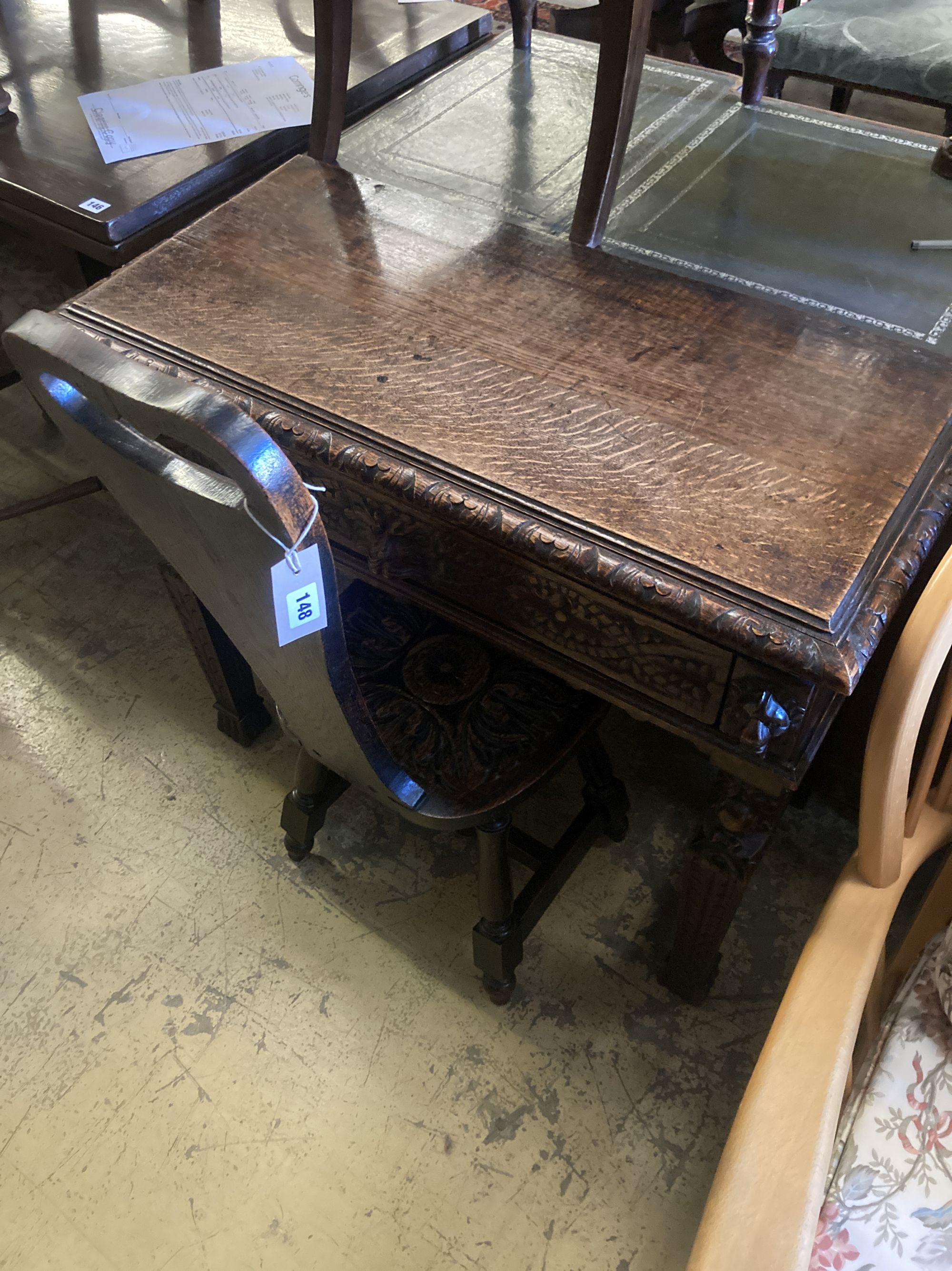 A late 19th century Flemish carved oak side table, width 88cm, depth 42cm, height 76cm, together with a carved oak spinning chair